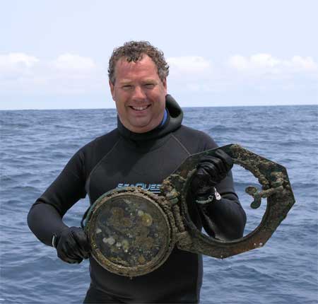 Diver Cliff Cason displays a porthole from the Monohan.  DiveHatteras photo